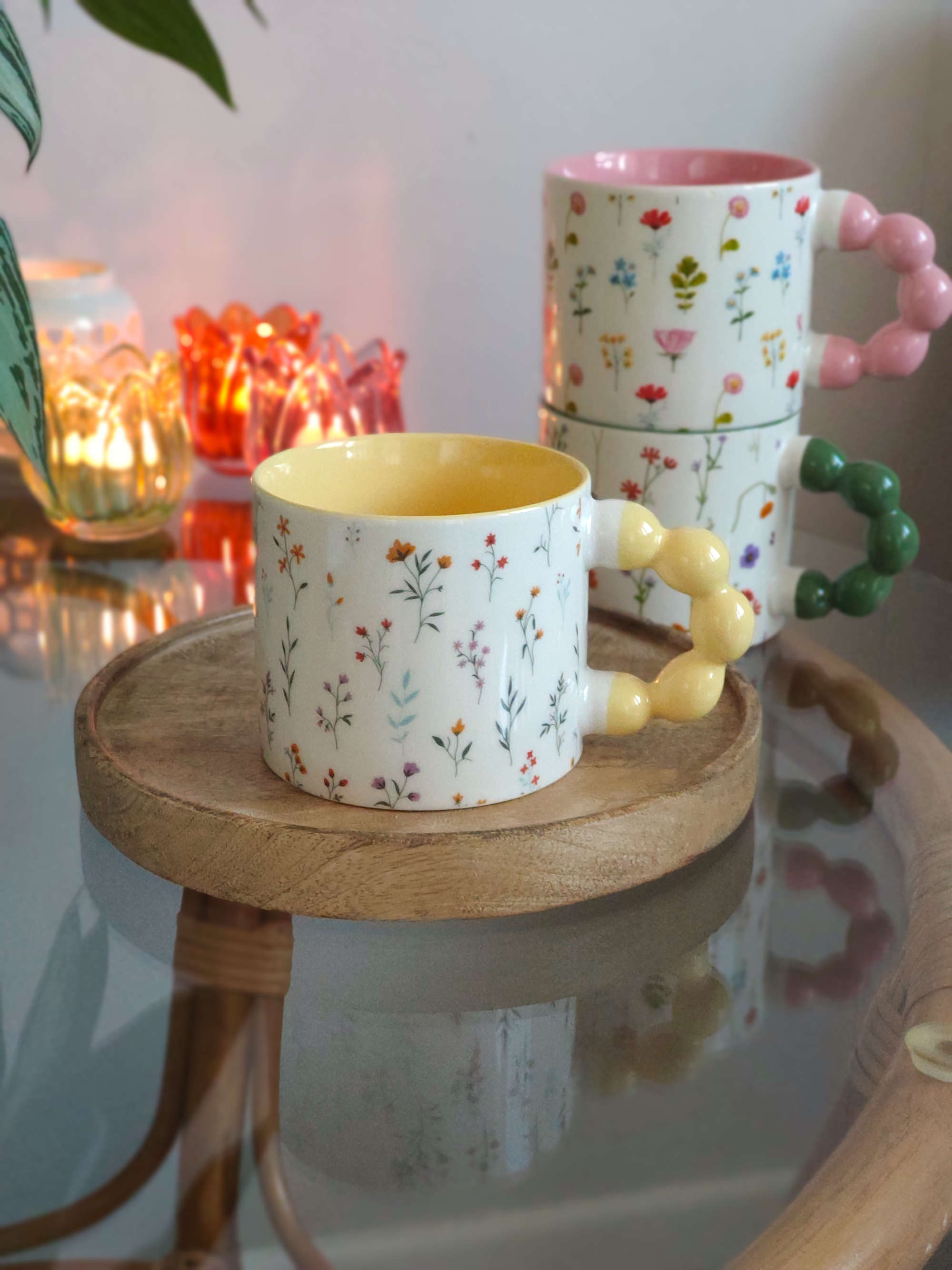 Becher Perlengriff gelb auf einem Glastisch